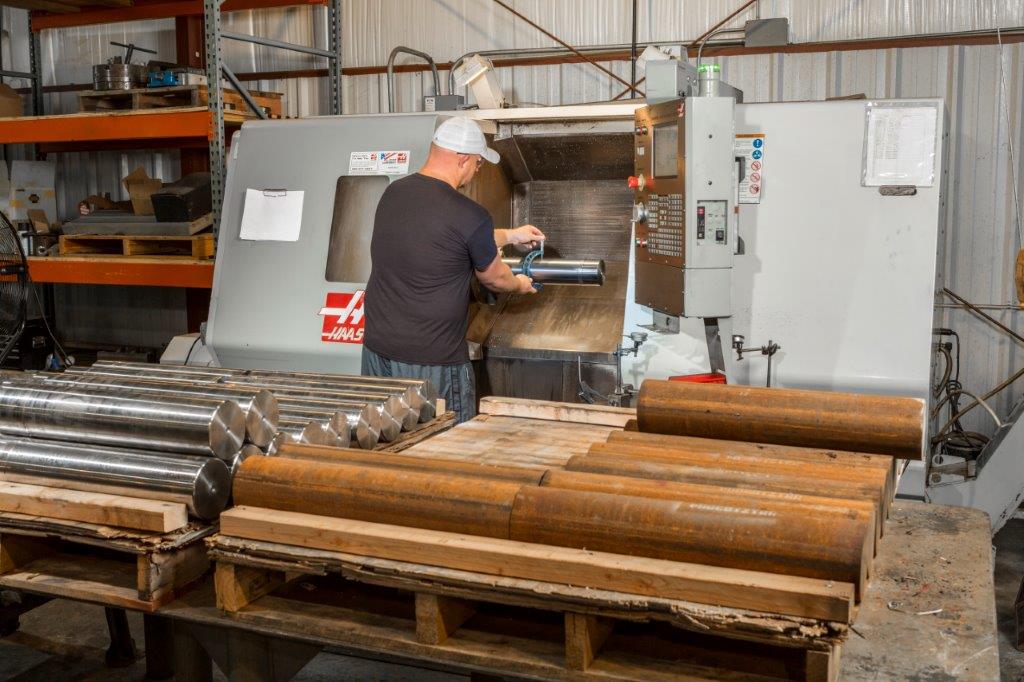 man reprocessing a used pump plungers