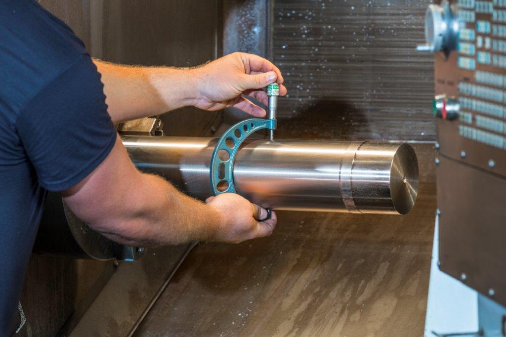 man reprocessing a used pump plungers