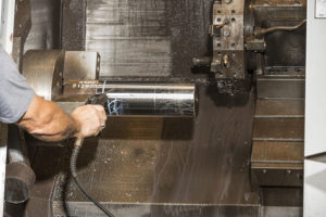 man processing a pump plunger